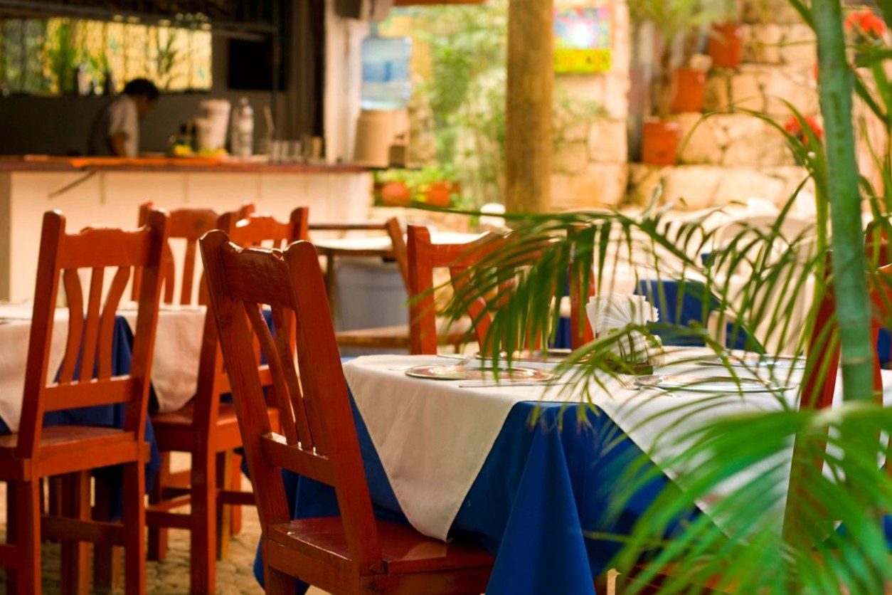 A table with two chairs and a blue and white cloth.