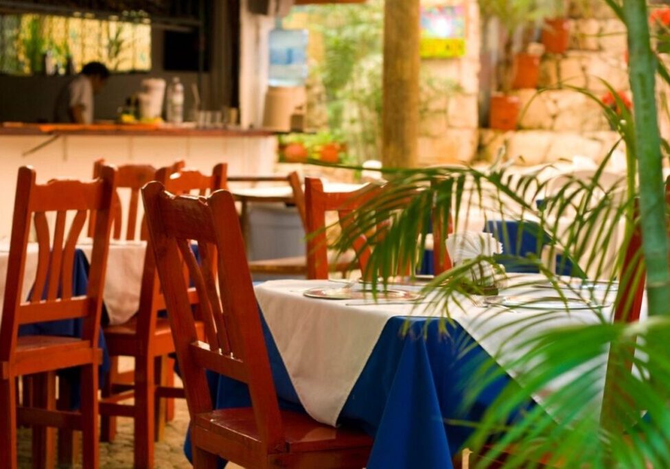 A table with two chairs and a blue and white cloth.